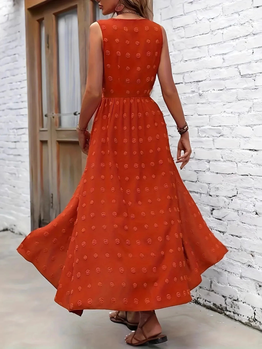 Woman wearing an orange dress with a white brick wall background-BlackOrvani
