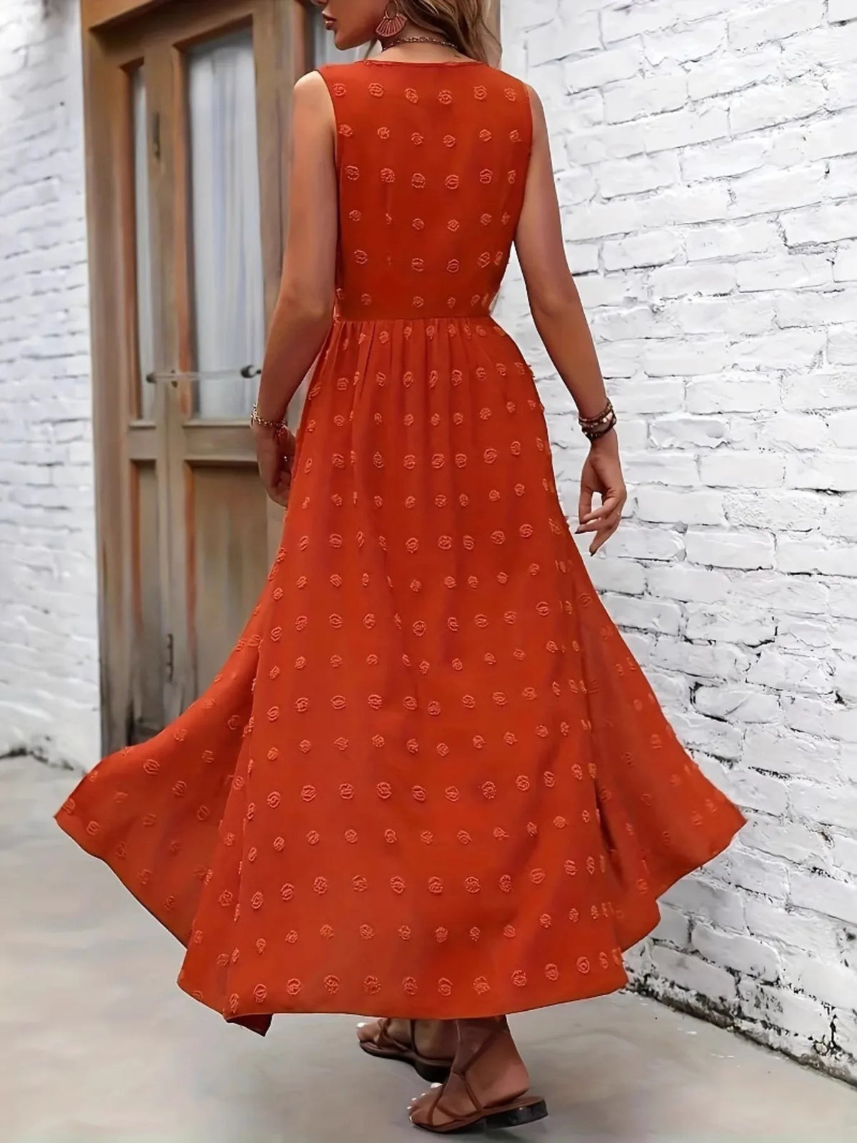 Woman wearing an orange dress with a white brick wall background-BlackOrvani