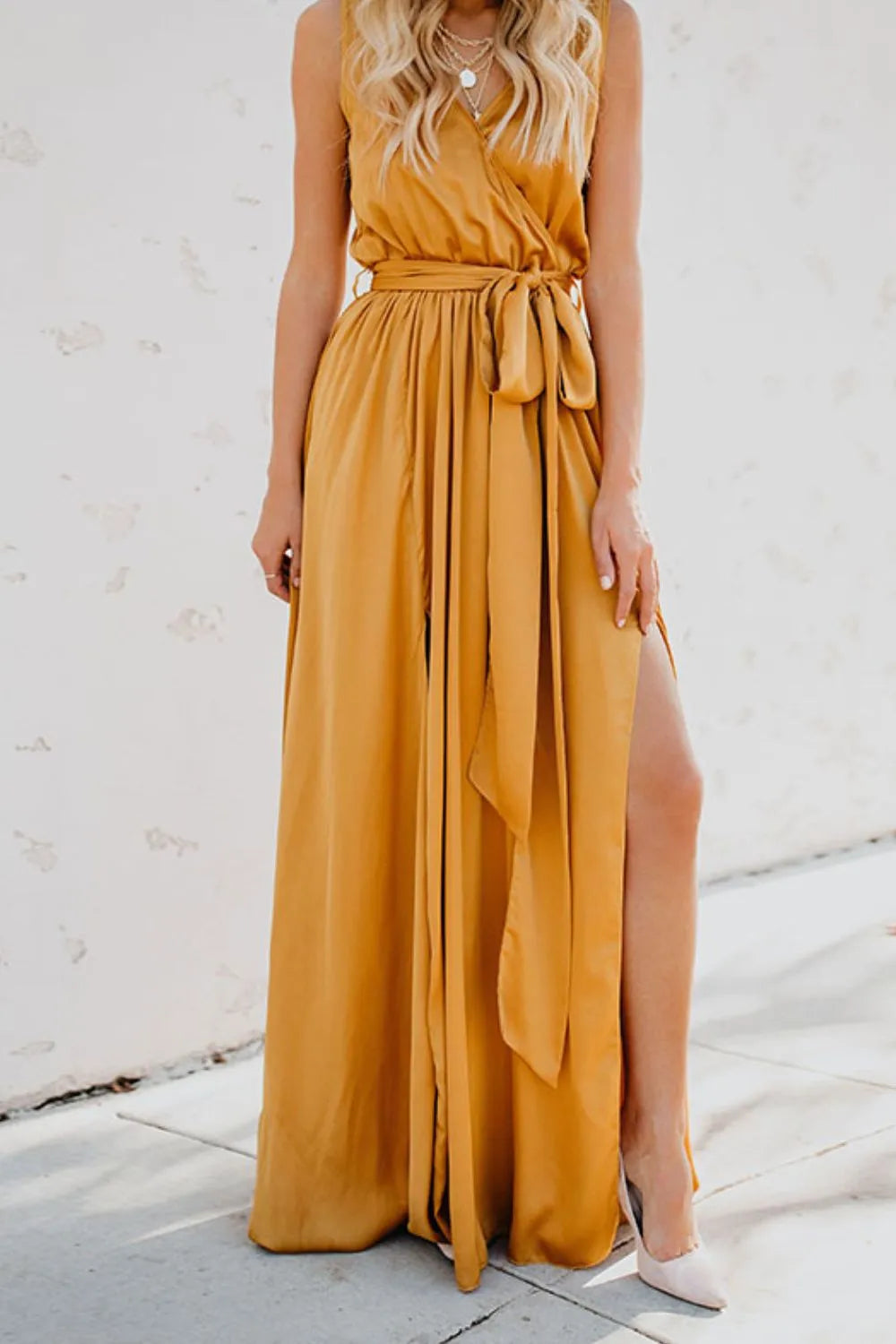 Woman wearing a mustard yellow sleeveless dress with a slit on a white background-blackorvani.com