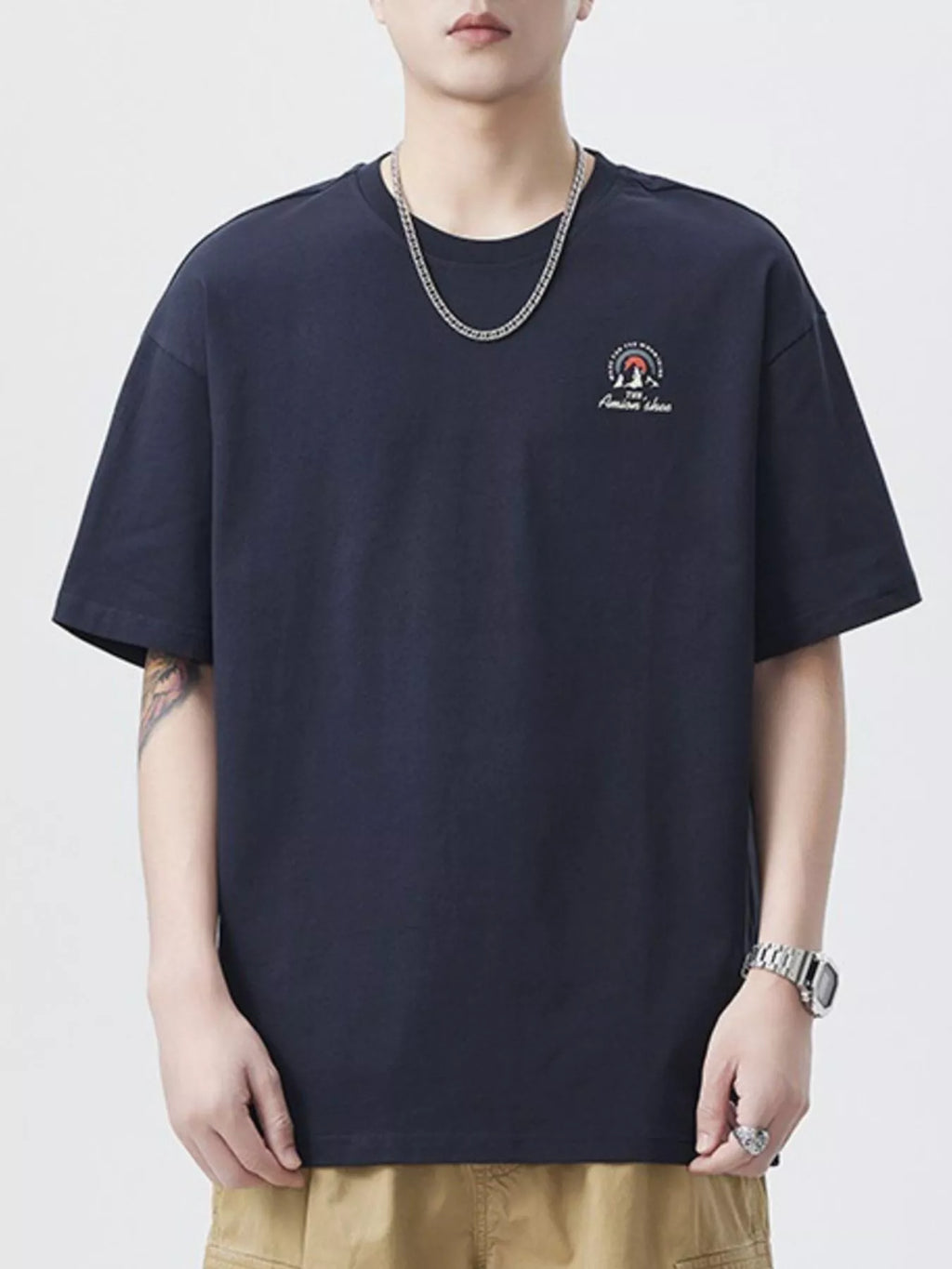Person wearing a navy blue t-shirt with a logo on a white background-blackorvani.com
