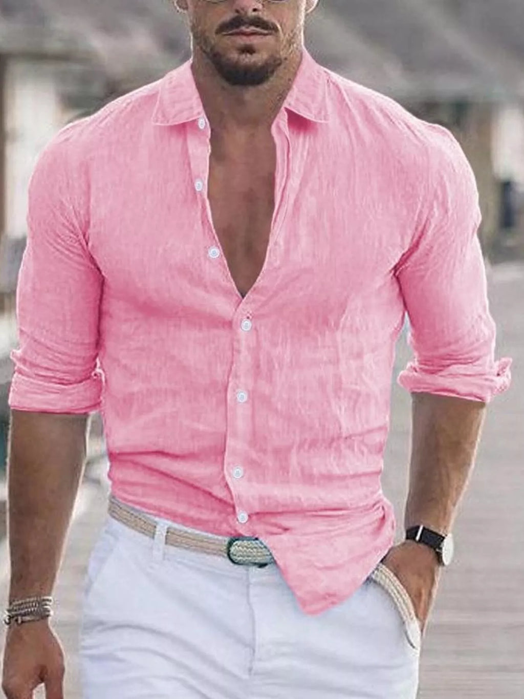 Man wearing a pink shirt and white pants outdoors