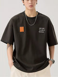 men wearing a black t-shirt with text and a patch on a plain background