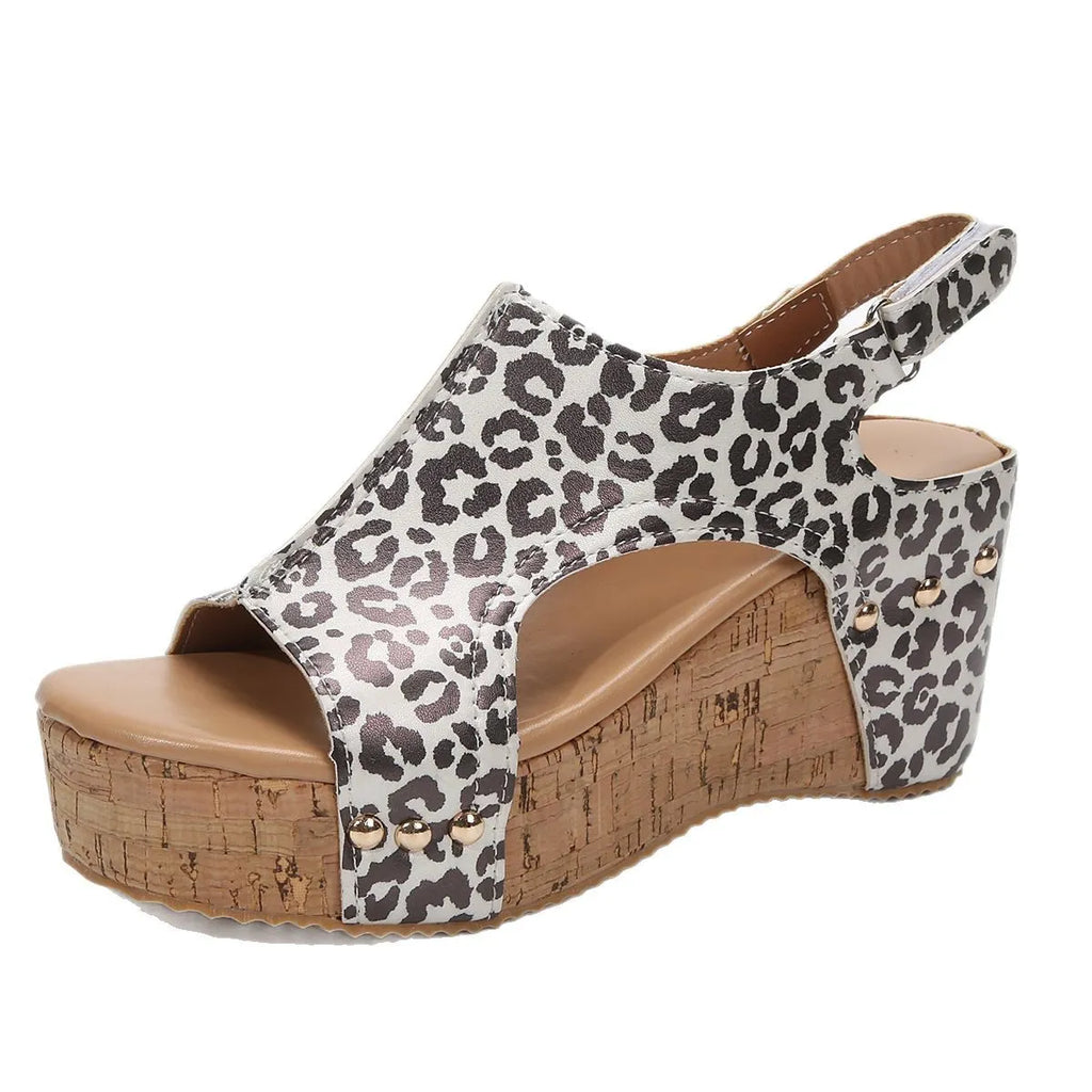 Wedge sandal with leopard print straps and cork platform on a white background