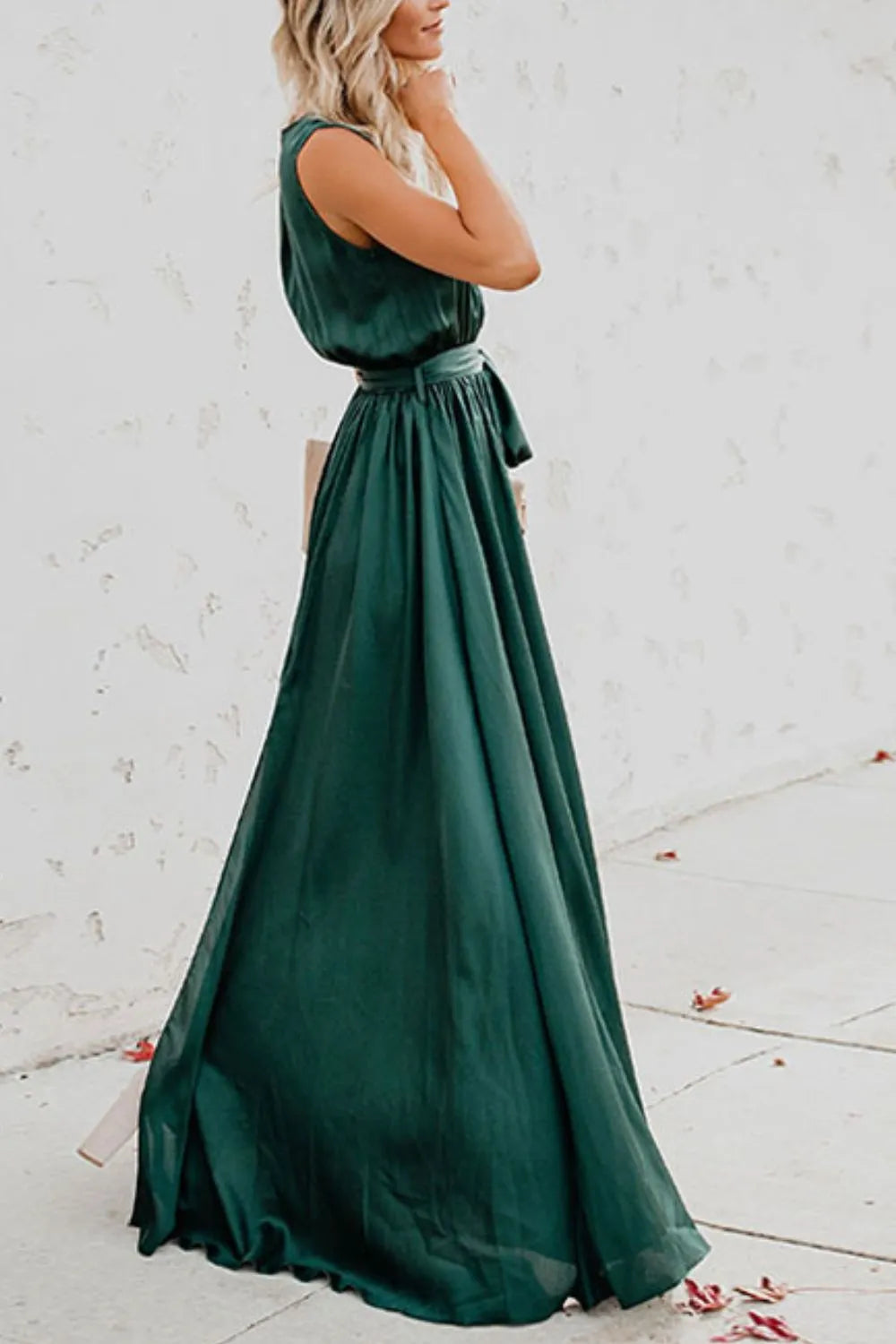 Woman wearing a long green dress against a white wall-blackorvani.com