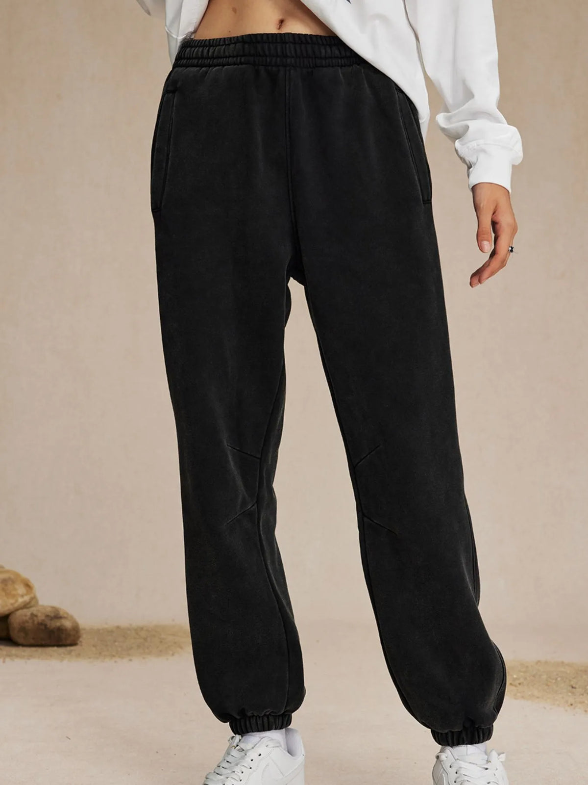 Black jogger pants worn by a person on a beige background-blackorvani.com