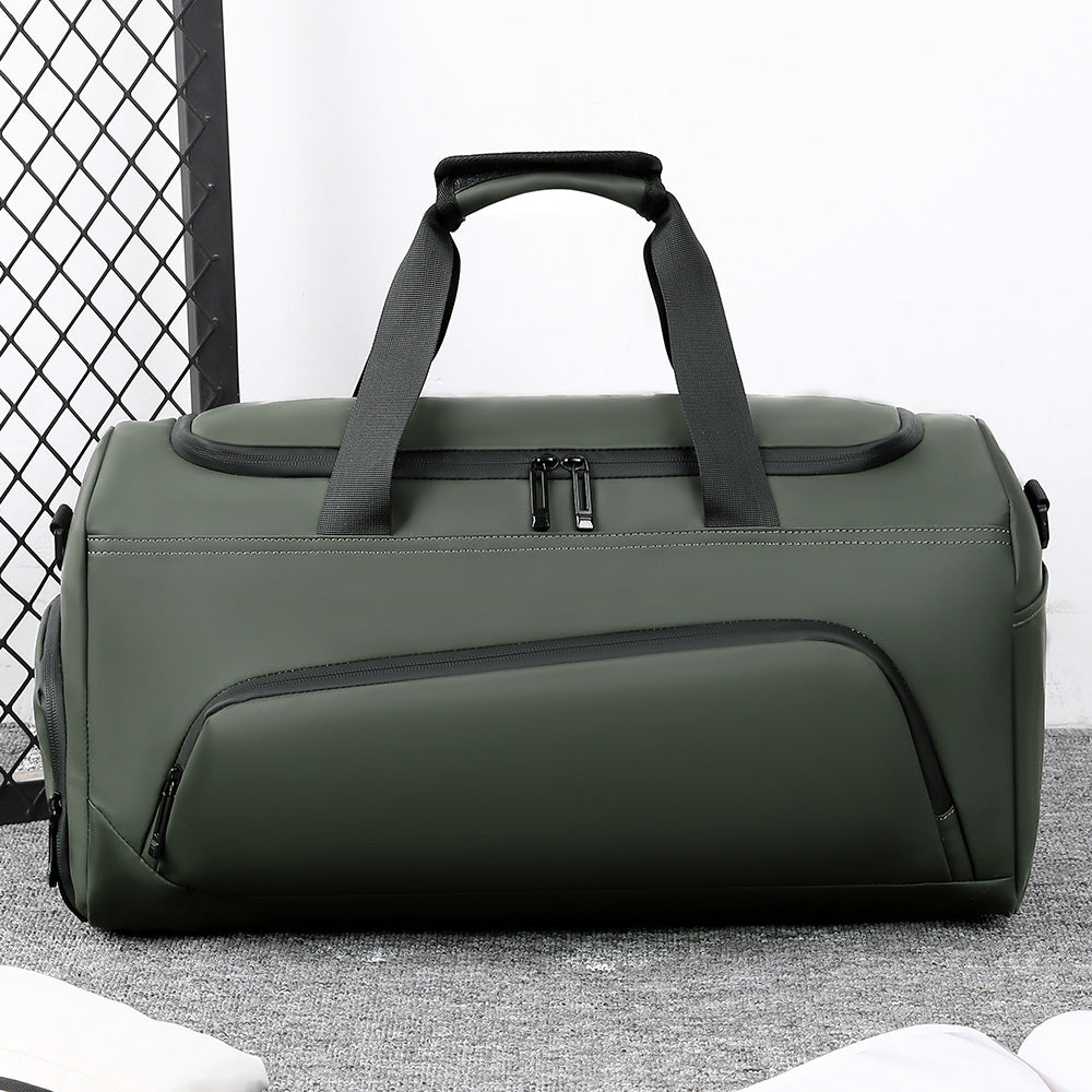 Green duffel bag with black handle on a light gray surface